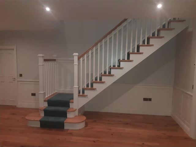 White oak cut-string staircase — Double bullnose step · panelled hall